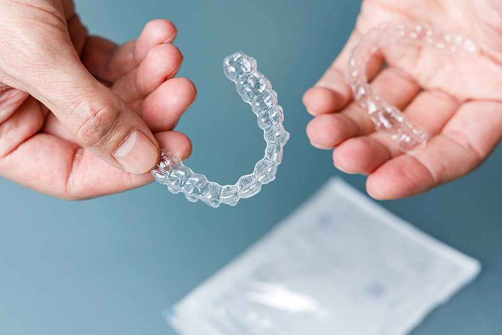 hands-holding-transparent-aligners-invisalign-ort